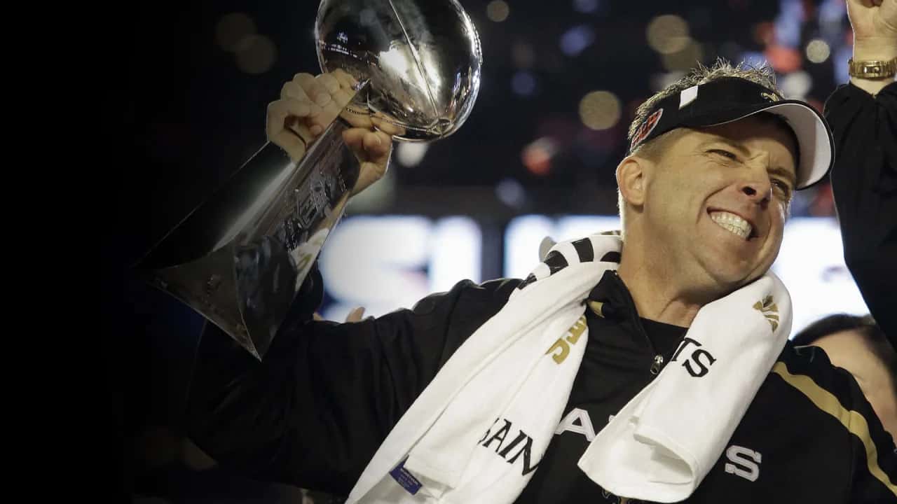 Sean Payton holding a super bowl trophy.
