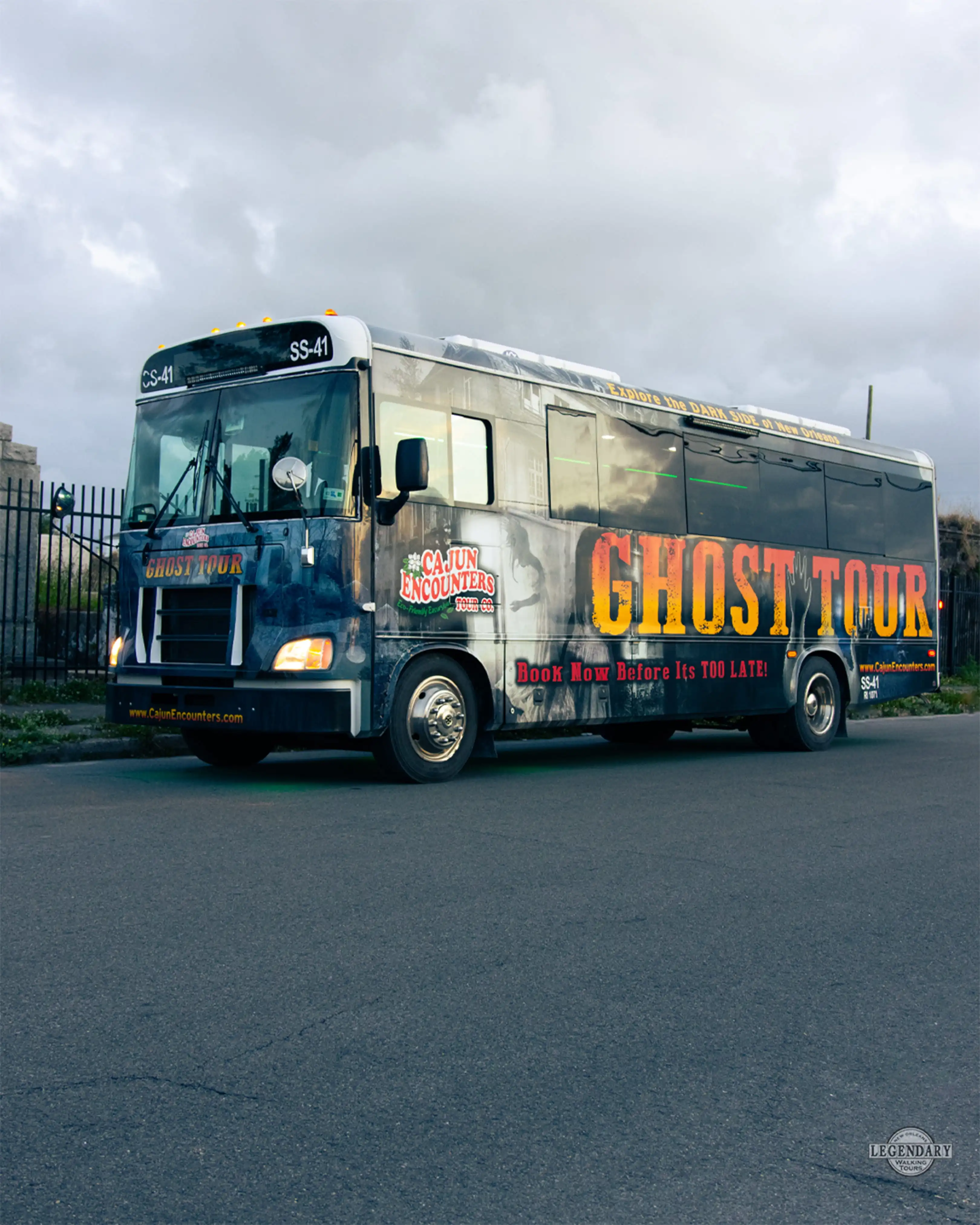 New Orleans ghost bus tour vehicle parked near a cemetery