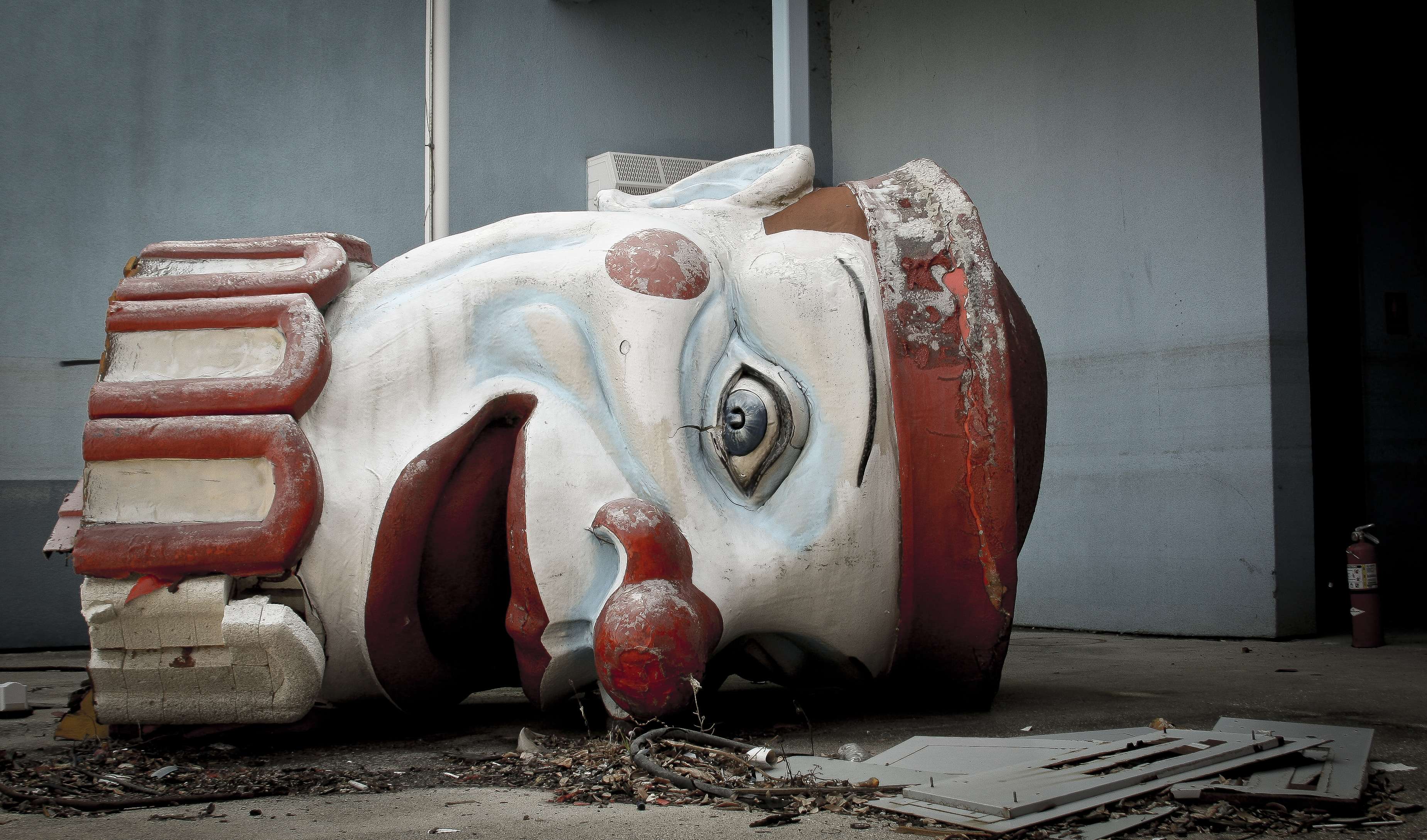 abandoned places in new orleans dilapidated clown head lying on the ground at Six Flags New Orleans