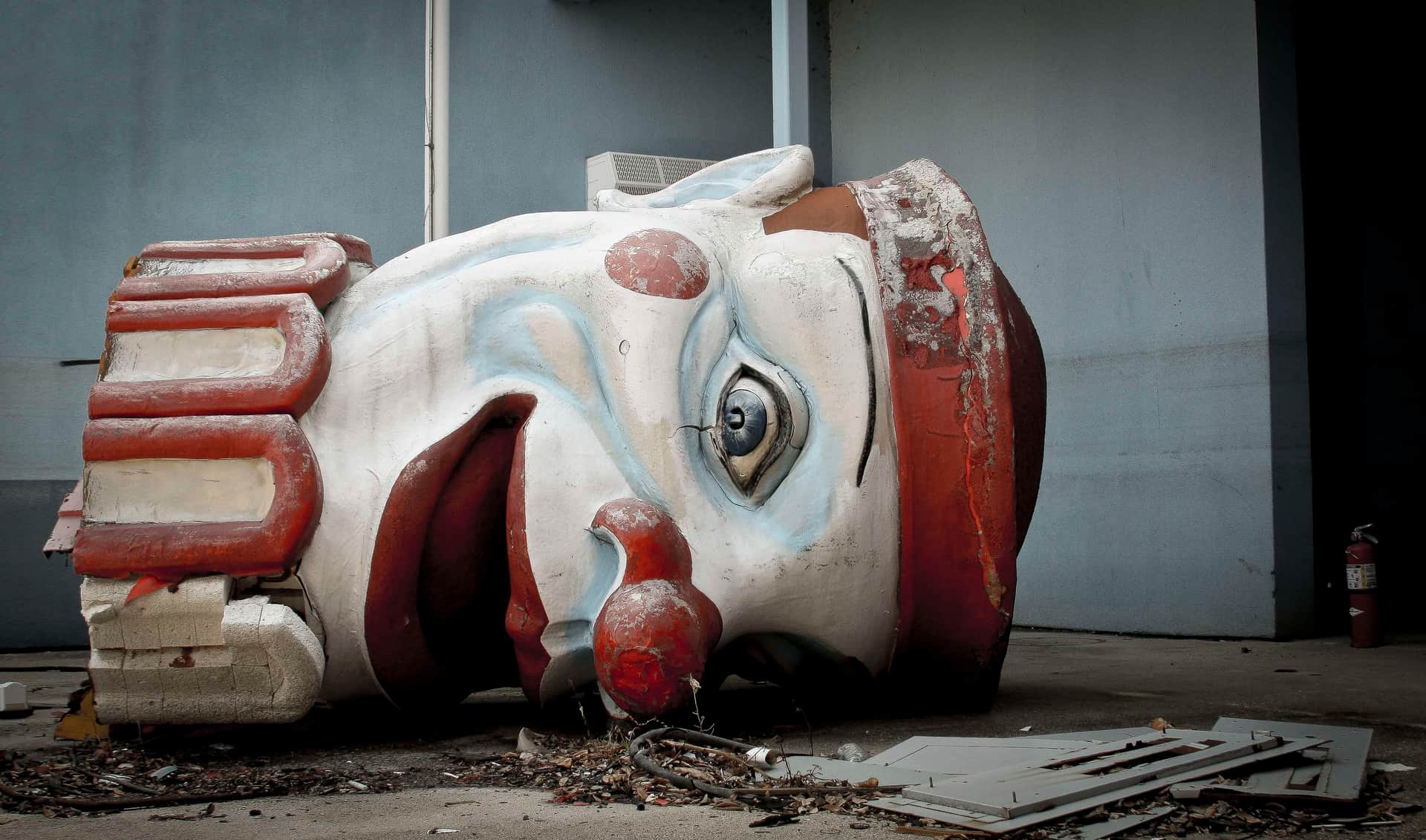abandoned places in new orleans dilapidated clown head lying on the ground at Six Flags New Orleans