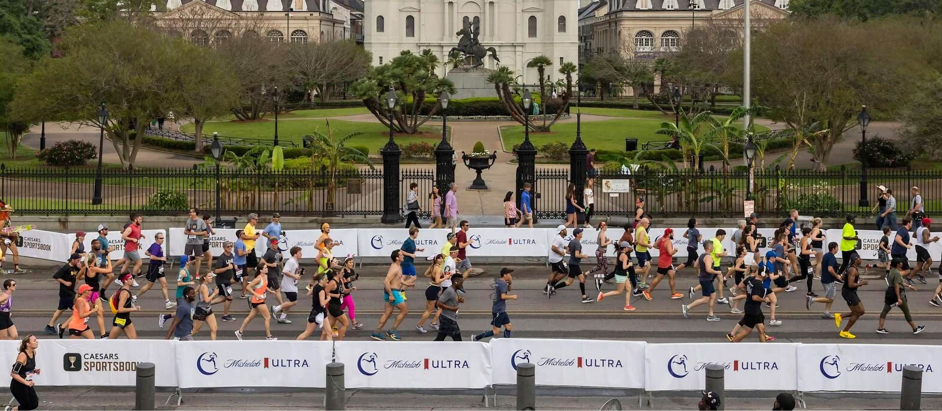 Runners in the Crescent City Classic 10k cross in front of Jackson Square