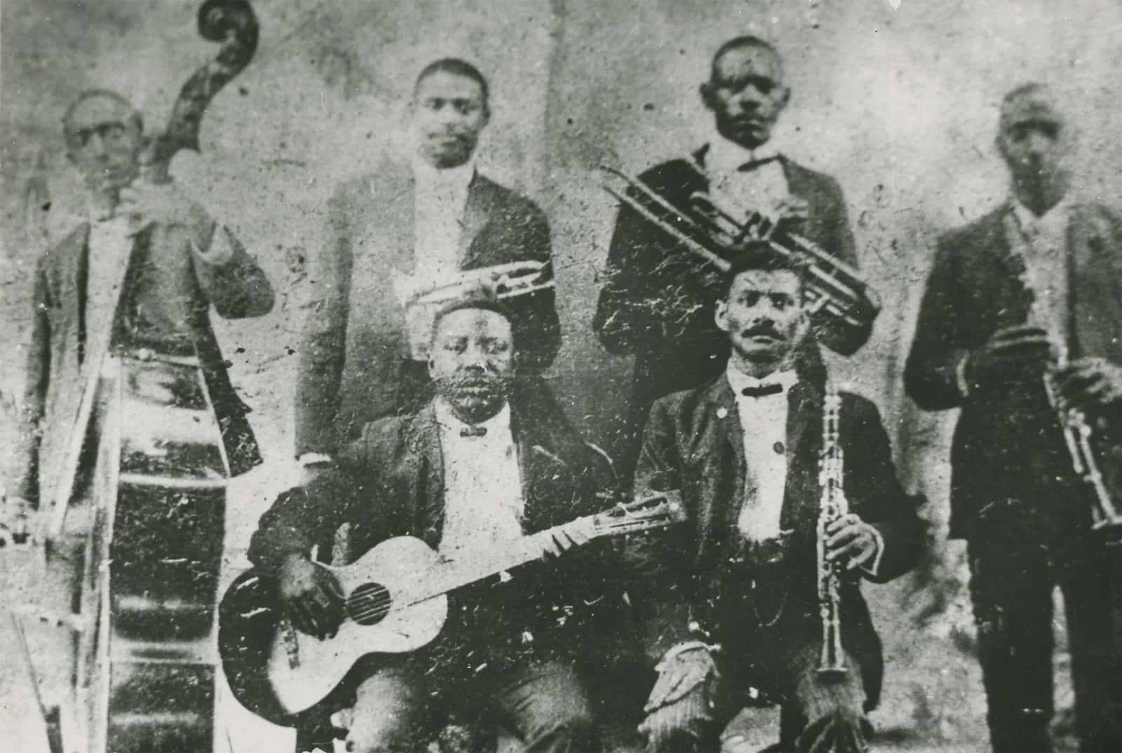 A black and white photo of Buddy Bolden in front of a brass band.